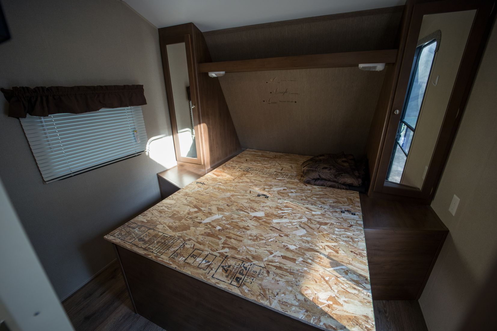 Original bedroom with dark wood trim and dirty gray walls.